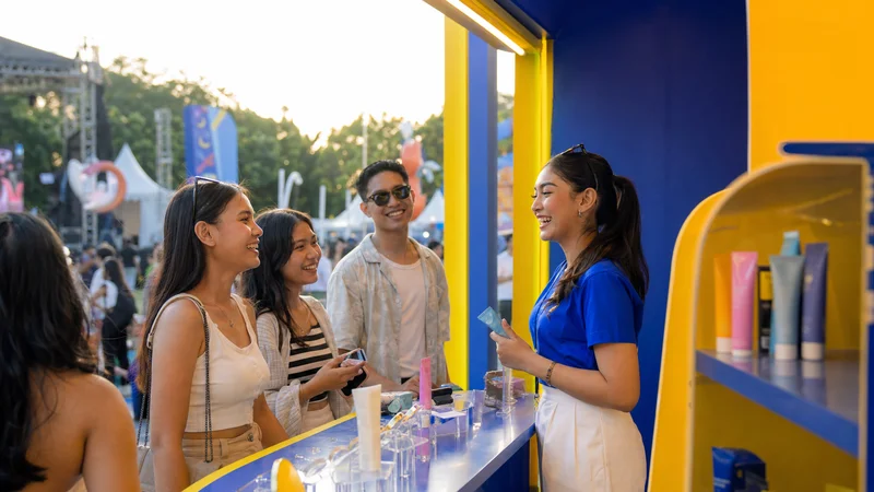 Booth aktivasi brand di festival outdoor dengan pengunjung yang antusias