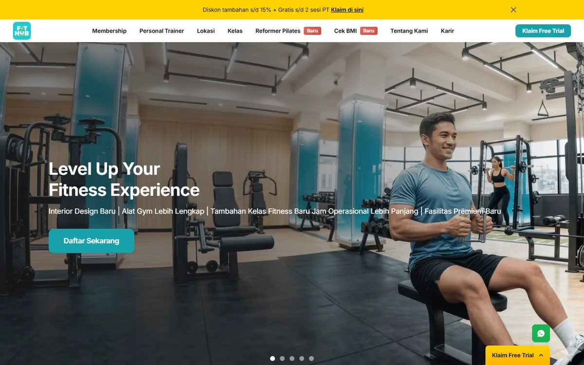 Screenshot beranda website FIT HUB dengan foto area gym, tombol Daftar Sekarang, dan tombol Klaim Free Trial